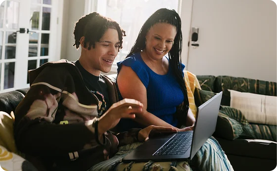 Mother and her son woking together with their laptop at home